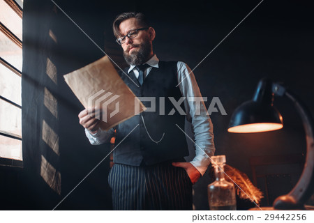 Bearded writer in glasses reads handwritten text Bearded writer in glasses reads handwritten text 29442256