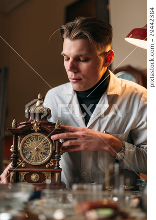 Watchmaker with old mechanical desk clock 29442384