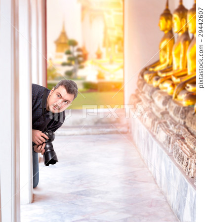 Photographer with digital camera in Buddha temple Photographer with digital camera in Buddha temple 29442607