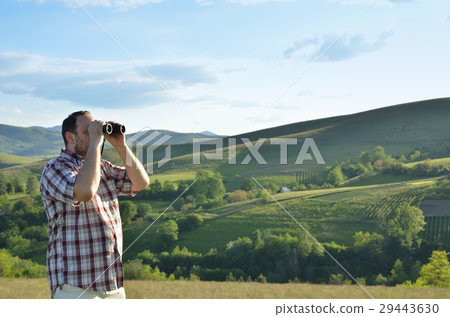 Man Watching Scenic Nature through Binoculars 29443630