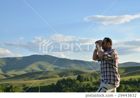 Man Watching Scenic Landscape through Binoculars 29443632