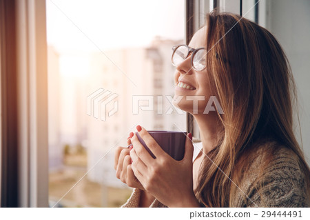 cheerful girl drinking coffee or tea in morning cheerful girl drinking coffee or tea in morning 29444491