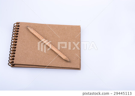 Pencil placed on a notebook on white background Pencil placed on a notebook on white background 29445113