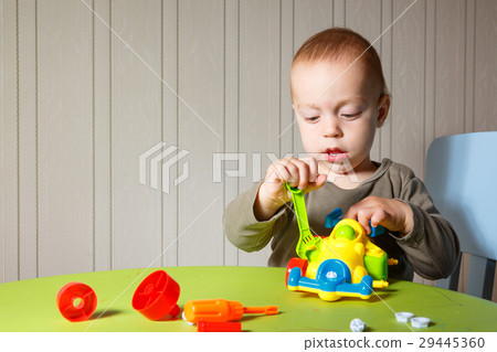 little boy repairs auto 29445360