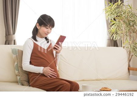A pregnant woman watching a smartphone 29446192
