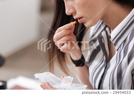 Close up of sick female taking pill Close up of sick female taking pill 29454033