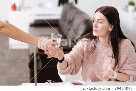 Attentive brunette holding handful of pills 29454073