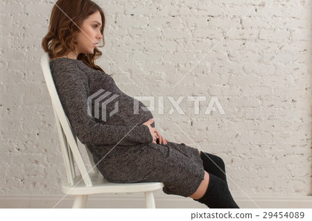Pregnant female sitting on chair posing Pregnant female sitting on chair posing 29454089