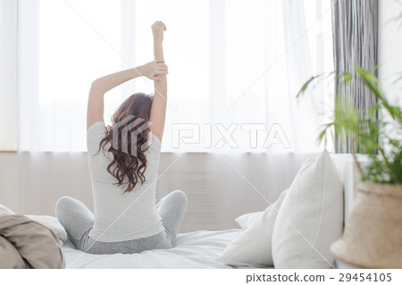 Female stretching sitting on bed in morning 29454105