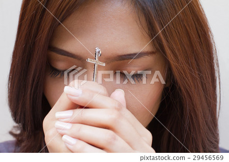 woman praying with holy cross, closed eye woman praying with holy cross, closed eye 29456569