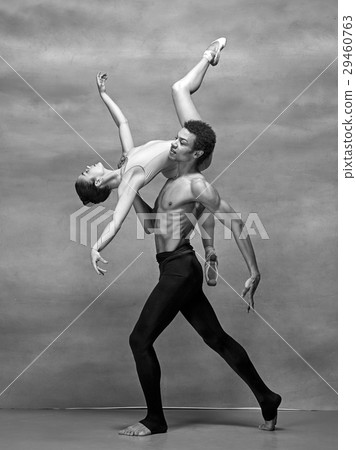 Couple of ballet dancers posing over gray Couple of ballet dancers posing over gray 29460763