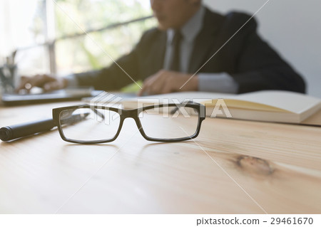 eyeglasses on desk wtih businessman analyze report eyeglasses on desk wtih businessman analyze report 29461670