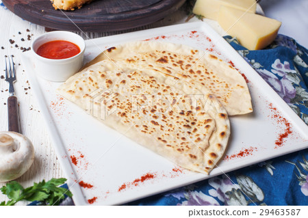 Flat lavash, flat khachapuri on a plate, still 29463587