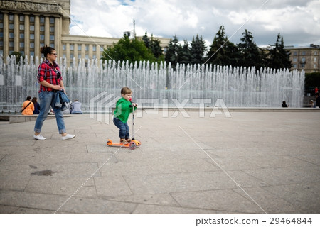 Small child rides a skateboard in park 29464844