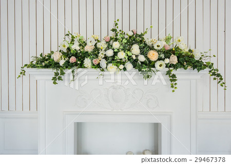 Bouquet of flowers over white fireplace in classic Bouquet of flowers over white fireplace in classic 29467378