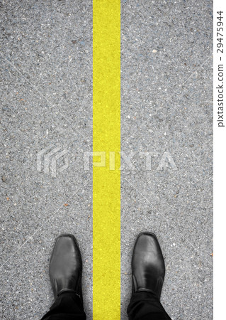 Black shoes standing on the floor and yellow line 29475944