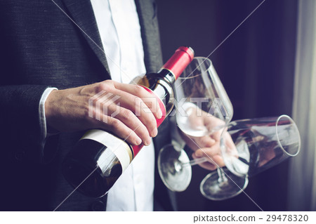 Man pouring red wine into a glass Man pouring red wine into a glass 29478320