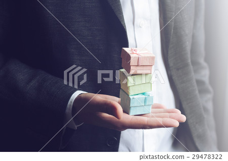 Man holding small gift boxes in his hand 29478322
