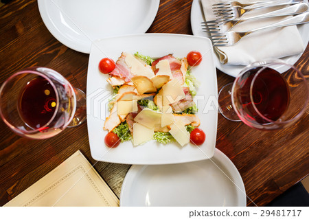 Caesar salad served on white plate in restaurant 29481717