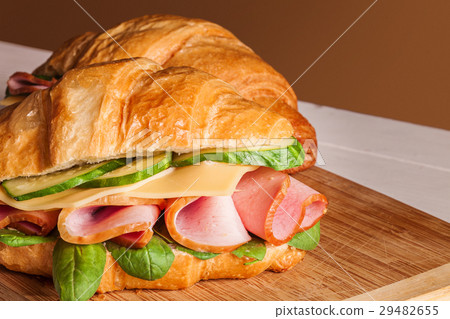 Croissants sandwiches on the wooden cutting board 29482655