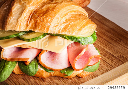 Croissants sandwiches on the wooden cutting board 29482659