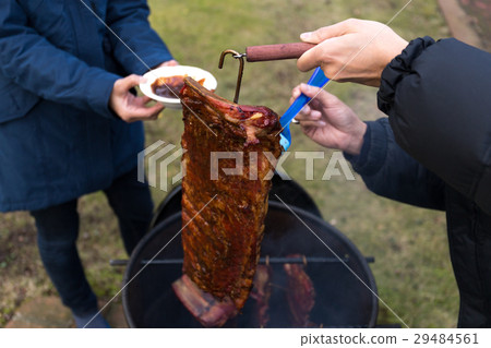 Man brushing sauce on barbecue spare ribs Man brushing sauce on barbecue spare ribs 29484561