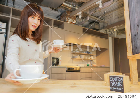 A young Japanese woman serving at a cafe 29484594