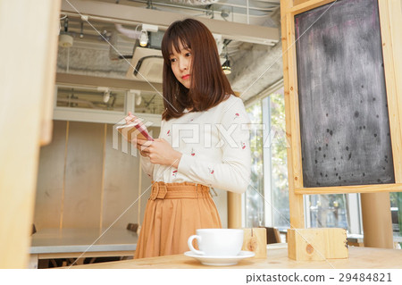 A young Japanese woman working in a cafe A young Japanese woman working in a cafe 29484821