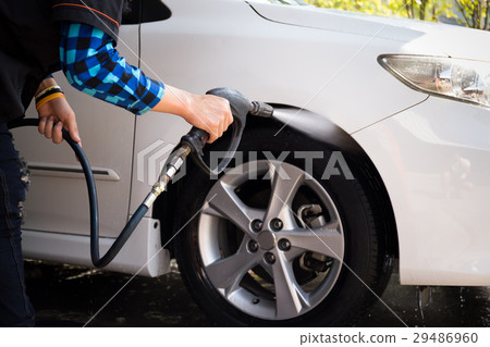 Man cleaning a car with high pressure cleaning 29486960