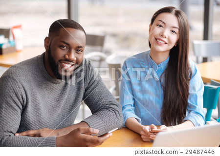 Young man and woman using smartphones at cafe 29487446