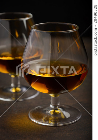 Glass of brandy or cognac on the old rusty table 29490329