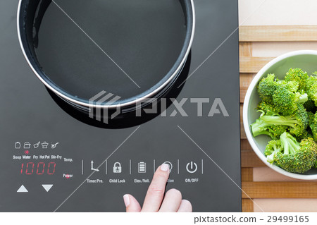 Woman select function on Induction stove 29499165