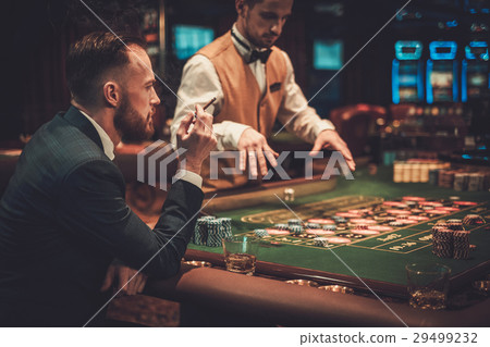 Upper class man gambling in a casino Upper class man gambling in a casino 29499232