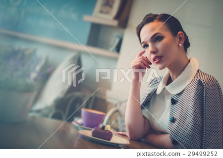 Elegant young lady alone in a cafe 29499252