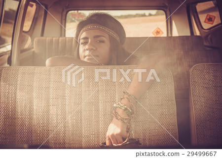Young black hippie woman in a retro van 29499667