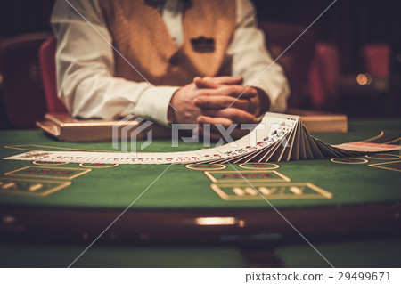 Croupier behind gambling table in a casino 29499671