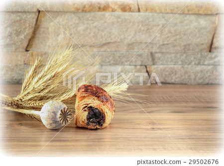 Sweet roll, head of poppy, spikelets lies on table 29502676
