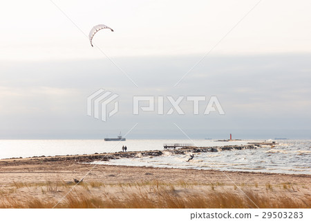 A couple walking along the lighthouse in a storm 29503283