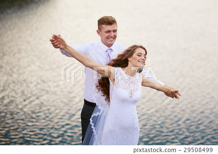 Happy bride and groom on a wedding walk near the Happy bride and groom on a wedding walk near the 29508499
