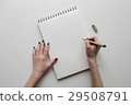 hands holding paper sheet or notebook and pen 29508791
