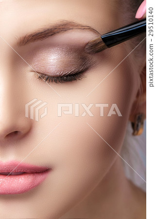 beautiful woman applying brown eye shadow using beautiful woman applying brown eye shadow using 29510140