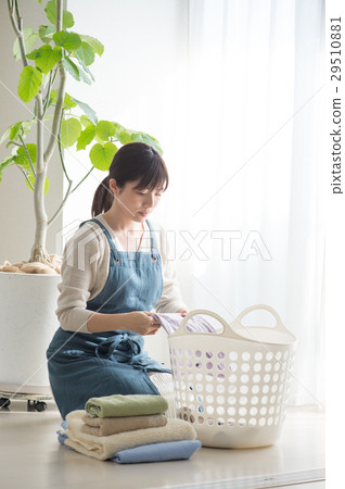 A young lady collapsing the laundry A young lady collapsing the laundry 29510881