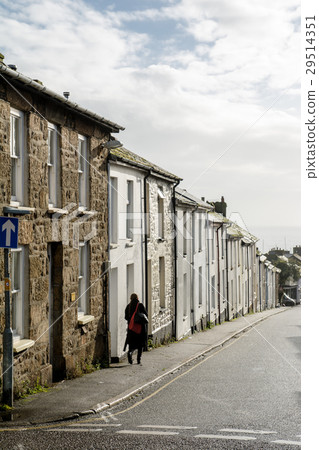 Streets of UK suburban stone houses and people walking on the sidewalk 29514351