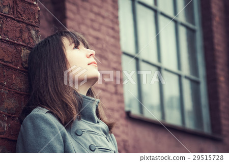 pensive beautiful young girl standing near a brick pensive beautiful young girl standing near a brick 29515728