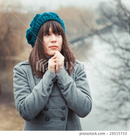 young pretty girl in cold weather in park outdoors 29515733