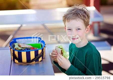 kid eating school lunch 29515798