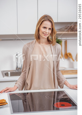 Cheerful housewife preparing dinner at home Cheerful housewife preparing dinner at home 29516085