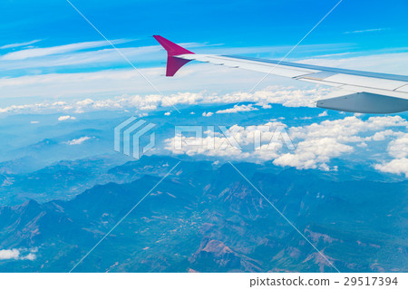 Wing of an airplane flying above the clouds . 29517394