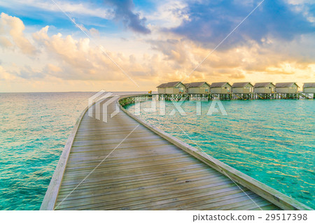 Beautiful water villas in tropical Maldives island at the sunset time . Beautiful water villas in tropical Maldives island at the sunset time . 29517398