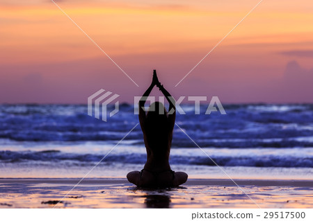 Silhouette young woman doing yoga on the beach at sunset Silhouette young woman doing yoga on the beach at sunset 29517500